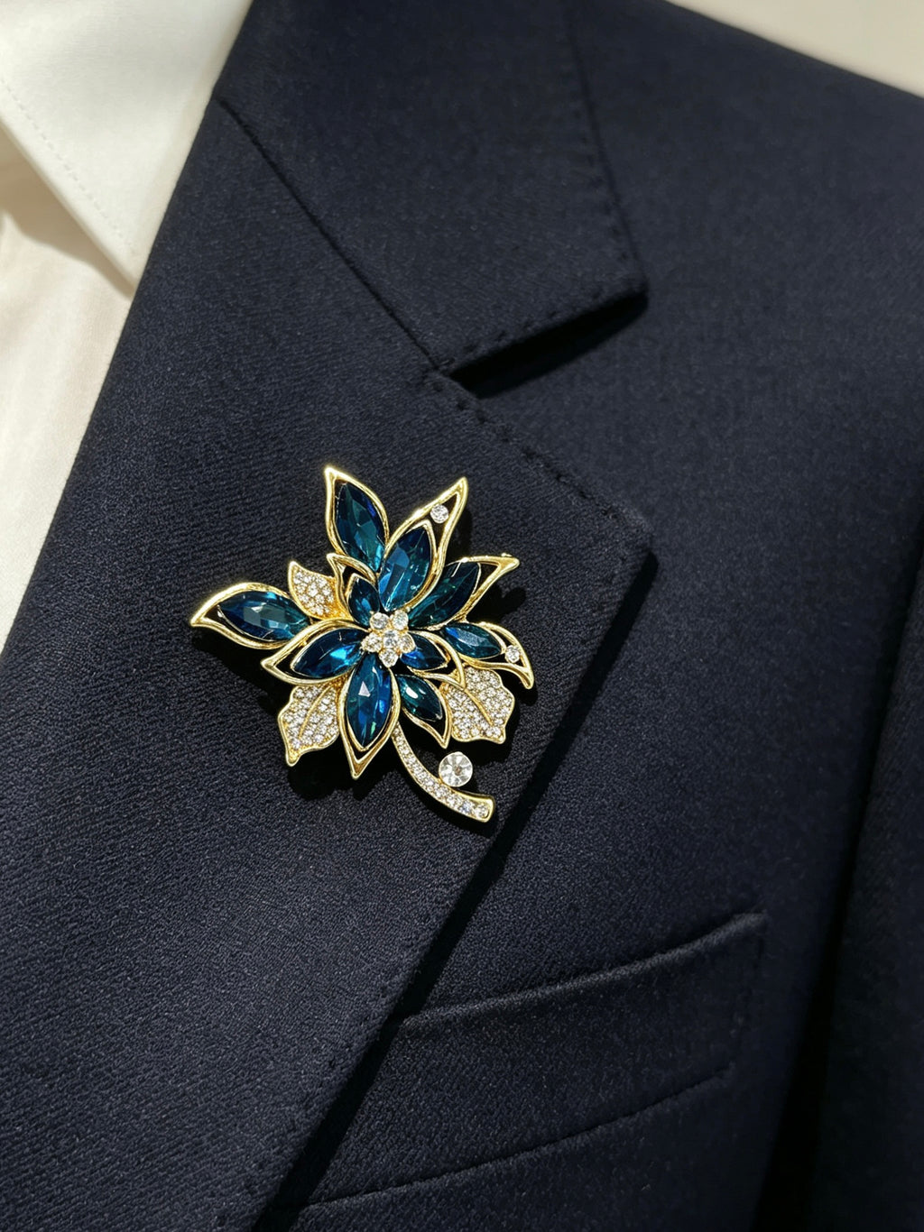 Crystal cluster brooch pin worn on a dark suit lapel