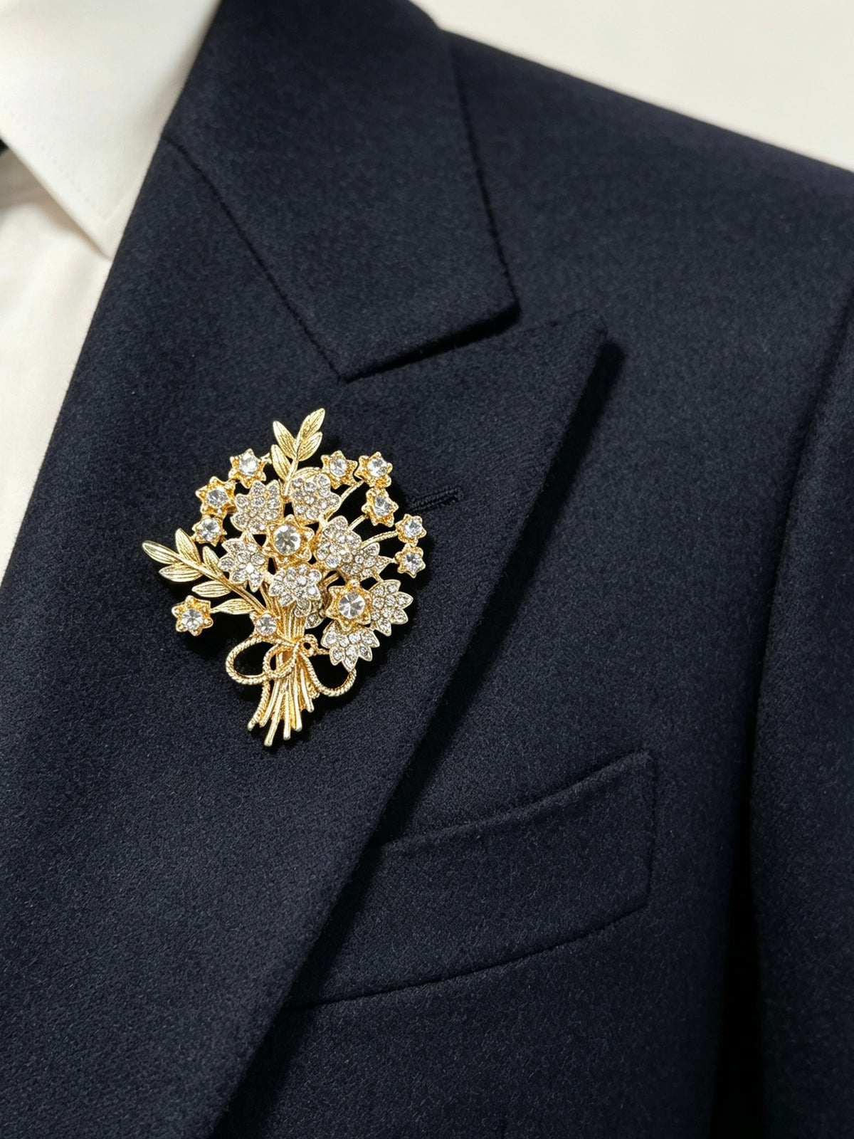 Crystal flower bouquet brooch pin worn on a dark suit lapel