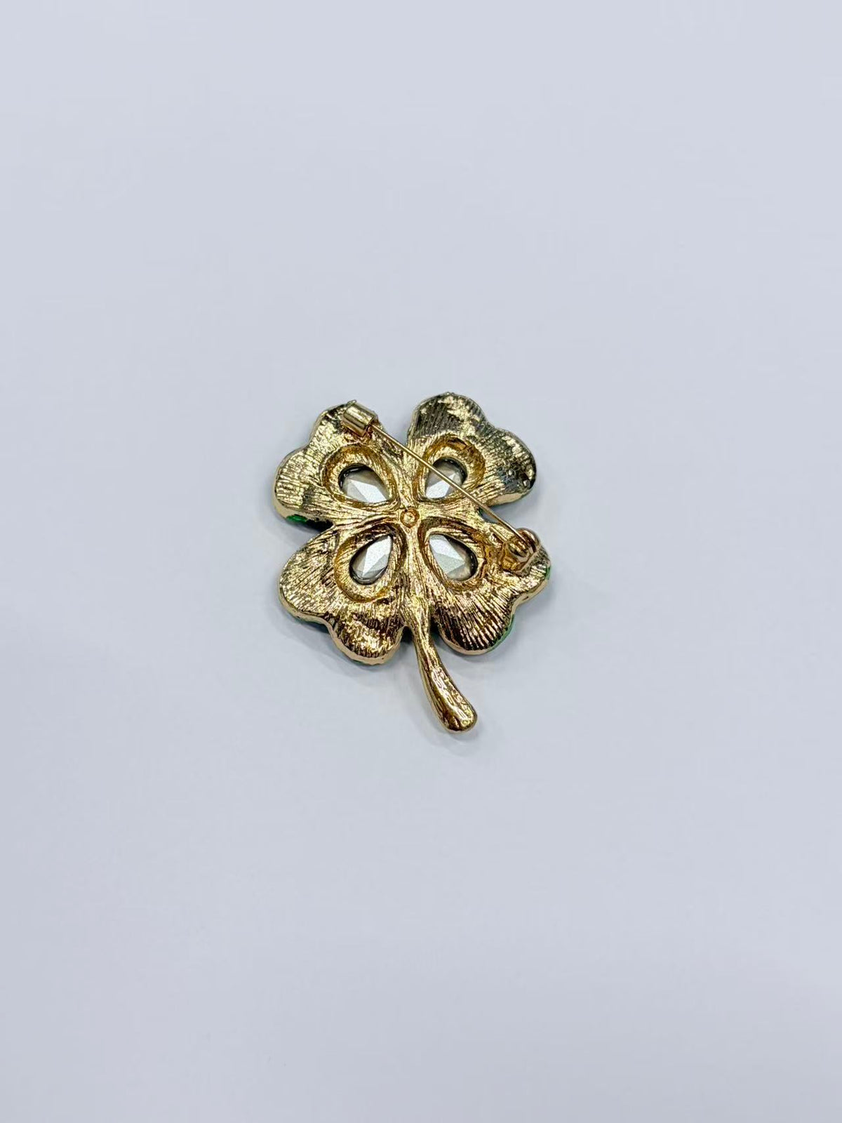 Crystal four leaf clover brooch pin back view on gray background