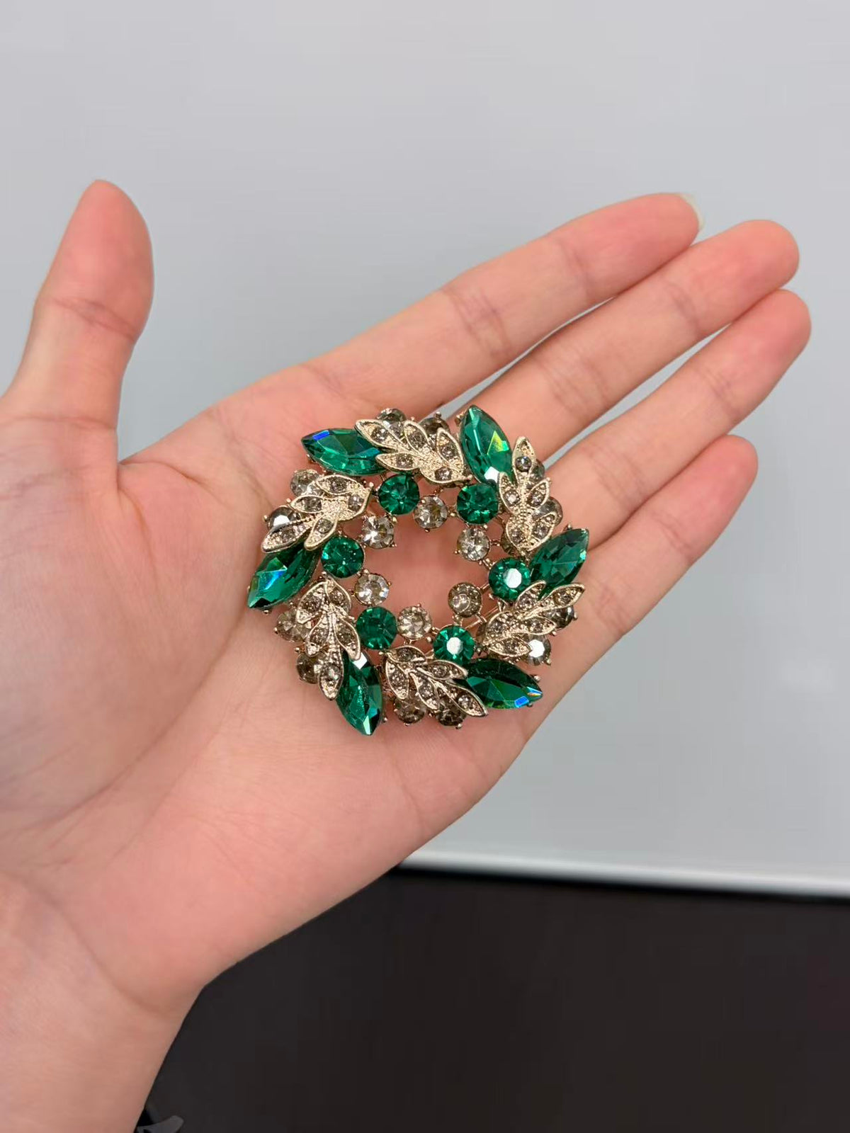Crystal leaf wreath brooch pin held in hand to show actual size