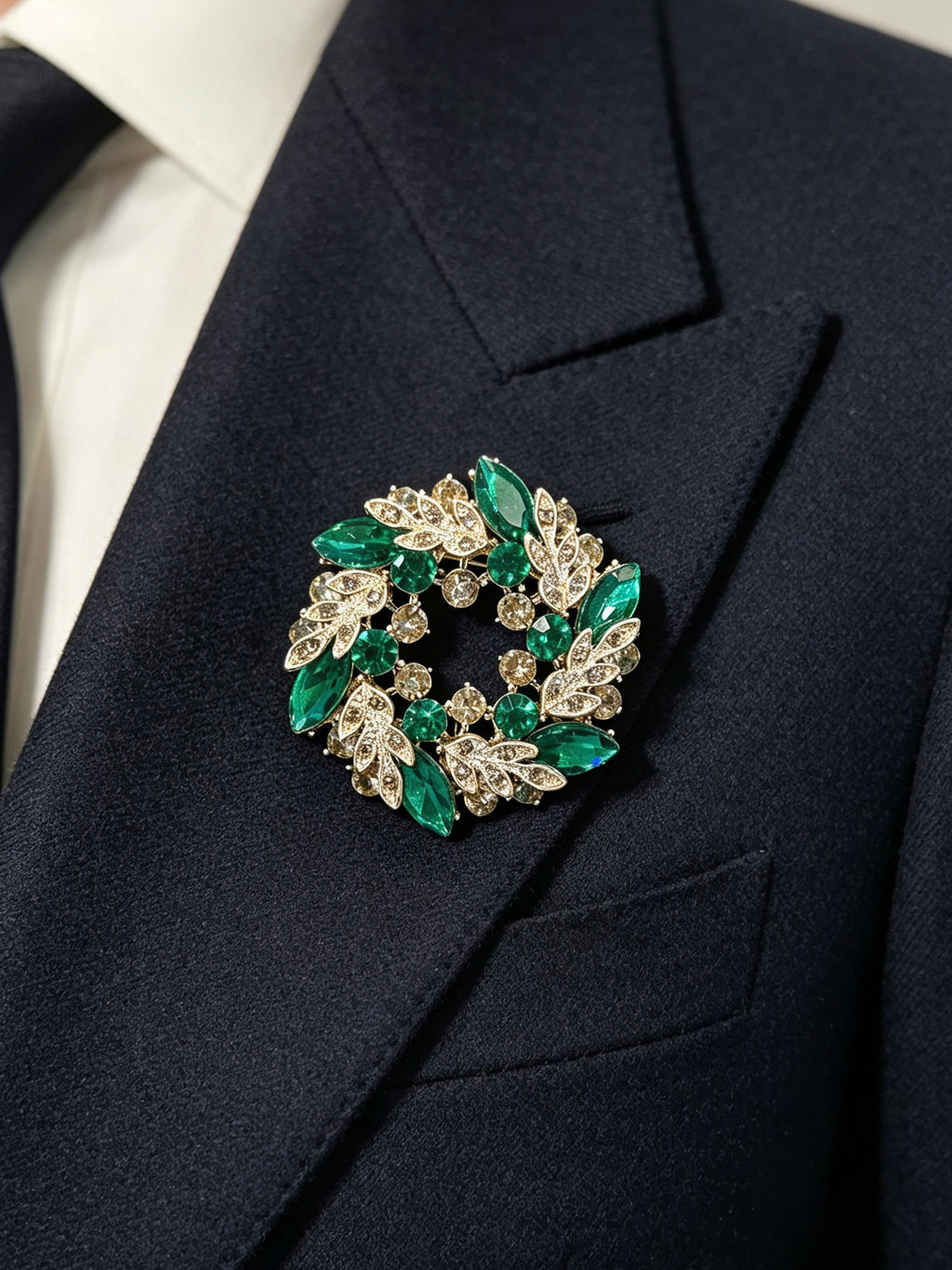 Crystal leaf wreath brooch pin worn on a dark suit lapel
