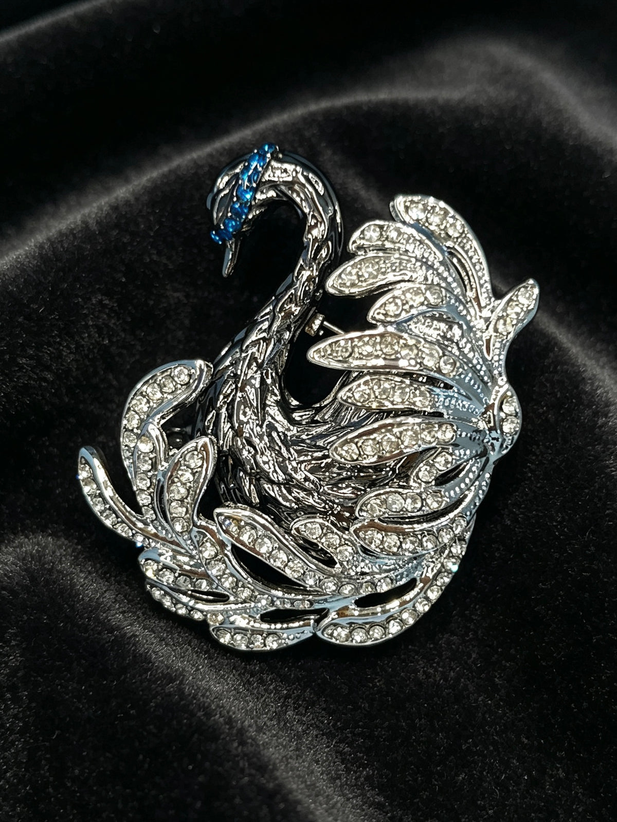 Crystal swan brooch pin close-up on black velvet