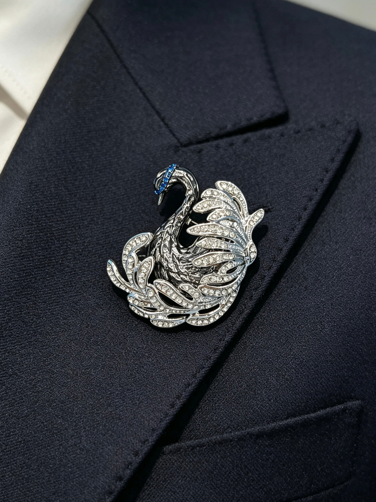 Crystal swan brooch pin worn on a dark suit lapel