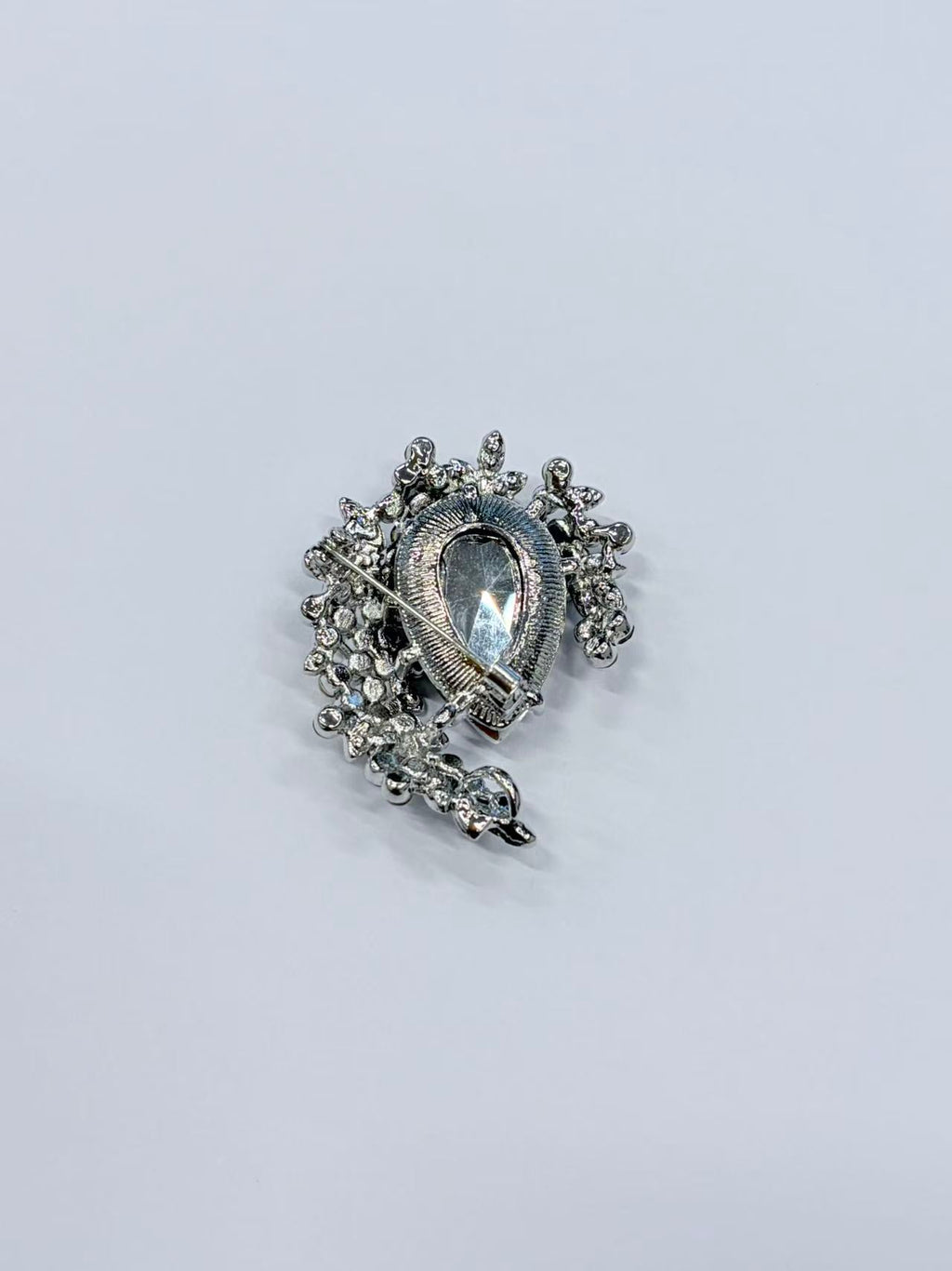 Crystal teardrop floral brooch pin angled view on gray background