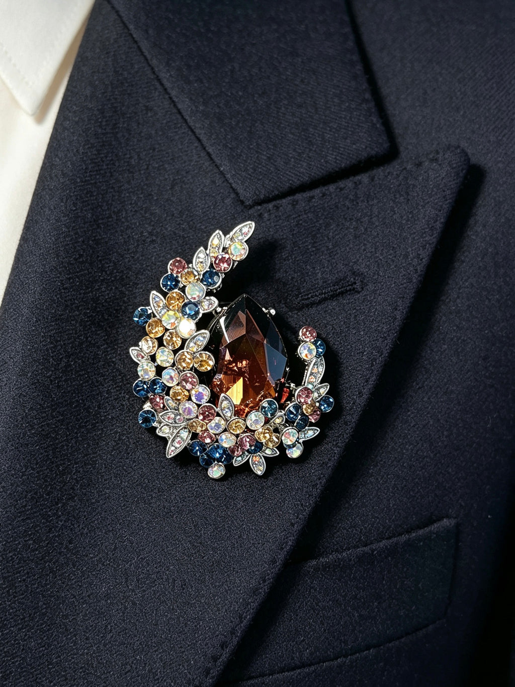Crystal teardrop floral brooch pin worn on a dark suit lapel